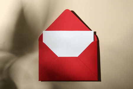 Blank greeting card and paper envelope on beige background, top viewの写真素材