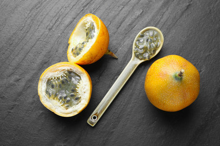 Ripe passion fruits and seeds on black table, flat layの写真素材