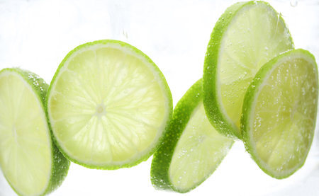 Refreshing soda water with slices of lime in glass on white background, closeupの写真素材