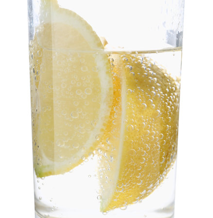 Refreshing soda water with slices of lemon in glass on white background, closeupの写真素材