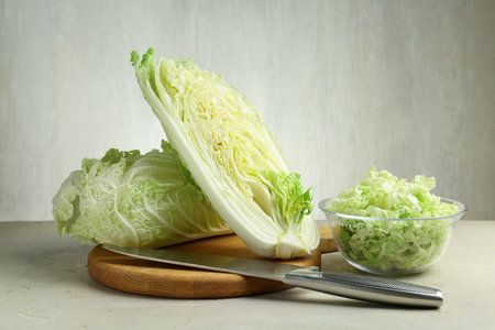 Fresh cabbages and knife on light grey table, closeupの写真素材