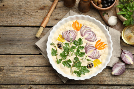 Raw focaccia with vegetables, olives, spices and brush on wooden table, flat lay. Space for textの写真素材