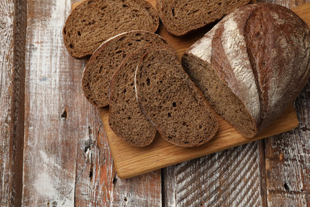 Pieces of fresh bread on wooden table, top view