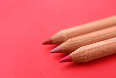 Three different lip pencils on red background, closeup. Space for textの写真素材