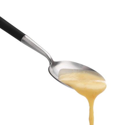 Delicious melted cheese flowing down from spoon isolated on whiteの写真素材