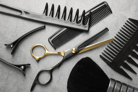 Different hairdresser's tools on grey table, flat layの写真素材