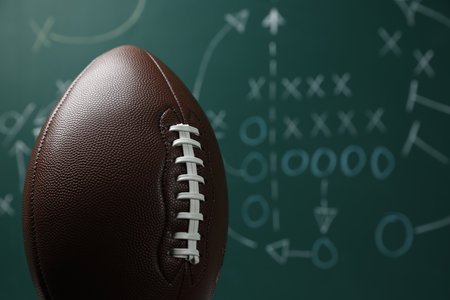 American football ball against blurred game scheme, closeupの写真素材