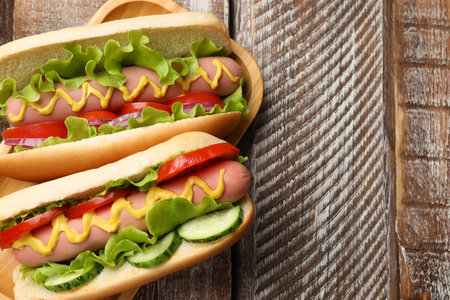 Tasty hot dogs on wooden table, top view. Space for textの写真素材
