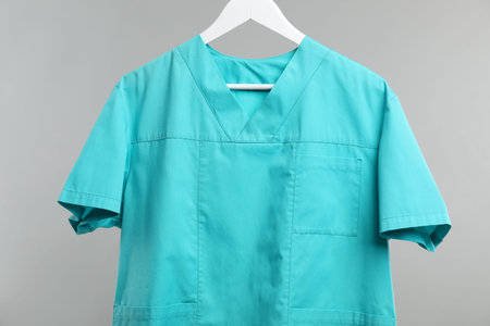 Medical worker uniform on hanger against grey backgroundの写真素材