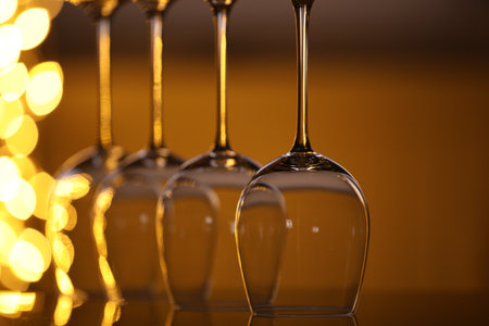 Many clean glasses on glass mirror surface against blurred lights, closeup. Bokeh effectの写真素材