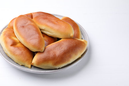 Tasty baked patties on white wooden table, closeup. Space for text