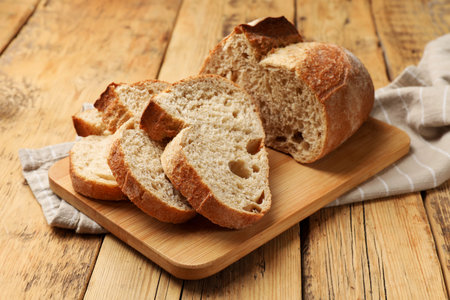 Pieces of fresh bread on wooden table, closeup