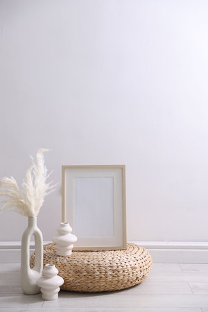 Empty picture frame and stylish home decor near white wall indoorsの写真素材