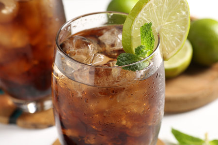 Tasty Cuba Libre cocktail in glass on table, closeup