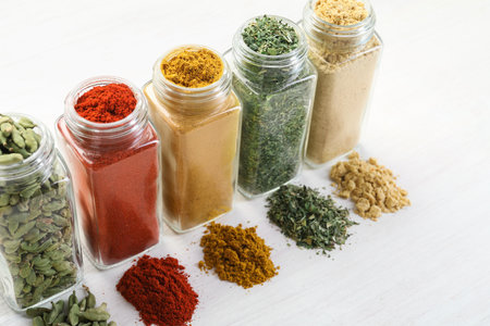 Different aromatic spices in jars on white table, closeupの写真素材