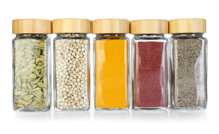 Many different aromatic spices in jars isolated on whiteの写真素材