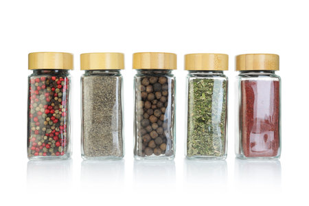 Many different aromatic spices in jars isolated on whiteの写真素材