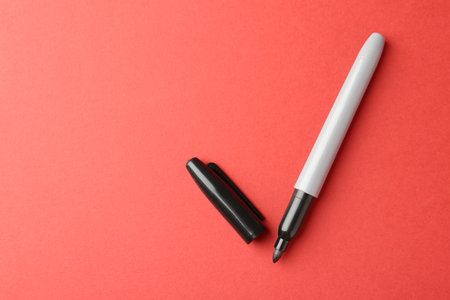 One black marker on red background, top view. Space for textの写真素材