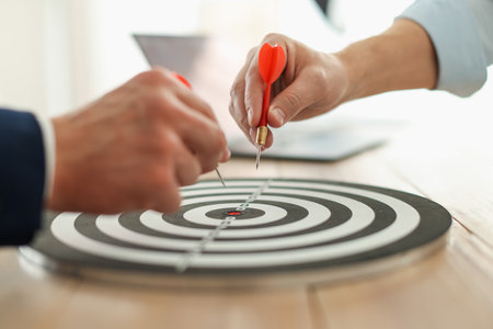 Men with darts aiming at dartboard indoors, closeupの写真素材