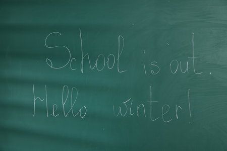 Phrases School Is Out and Hello Winter with exclamation mark on blackboardの写真素材