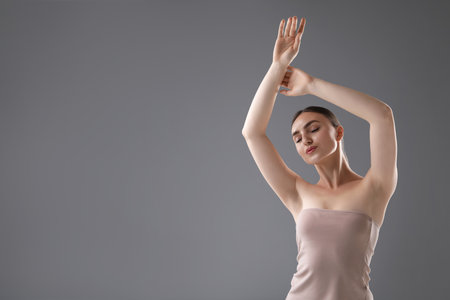 Portrait of beautiful woman on grey background. Space for textの写真素材