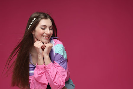 Fashionable portrait of beautiful woman in stylish outfit on crimson background. Space for textの写真素材