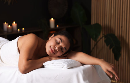 Beautiful woman relaxing on massage couch in spa salonの写真素材