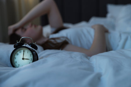 Frustrated young woman suffering from insomnia on bed indoors, selective focusの写真素材
