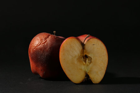 Damaged red apples on black background, closeupの写真素材