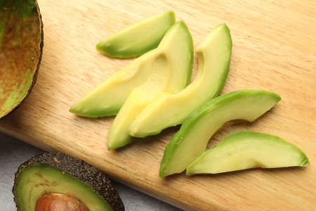 Cut ripe green avocado on table, top view