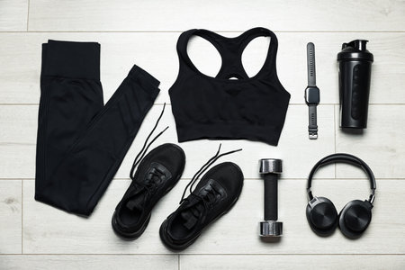 Sportswear, sneakers, wrist watch, headphones and dumbbell on floor, flat layの写真素材