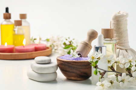 Spa composition with cosmetic products, beautiful flowers and burning candles on white background, selective focusの写真素材