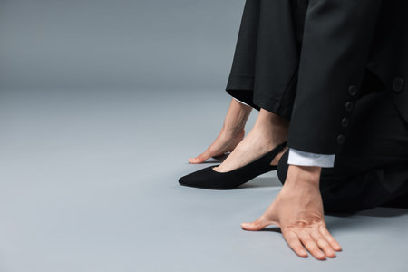 Businesswoman in starting position on gray background, closeup. Space for textの写真素材