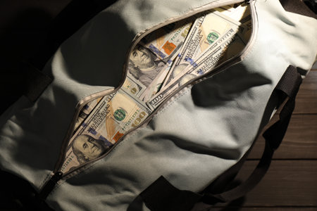 Bag with dollar banknotes on wooden table, top viewの写真素材