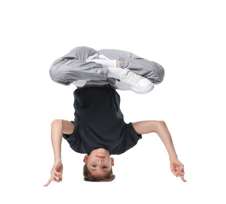 Boy in stylish clothes dancing on white background