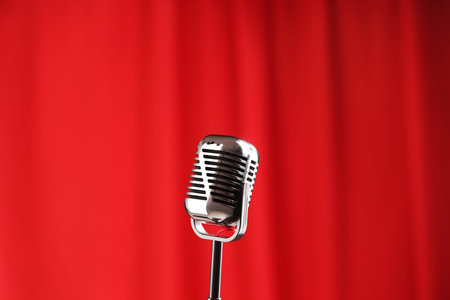 One vintage microphone against red curtain. Musical equipmentの写真素材