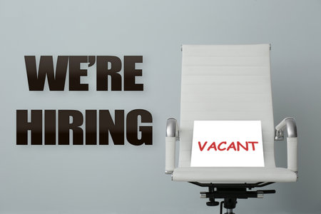 Office chair with Vacant sign on grey background.の写真素材