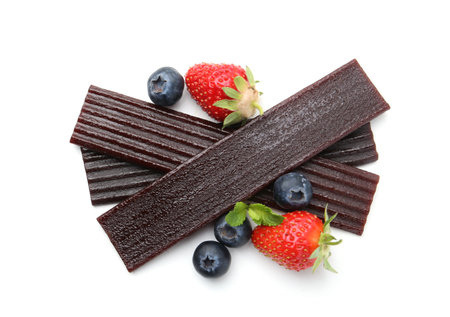 Tasty fruit leather, strawberries and blueberries isolated on white, top view