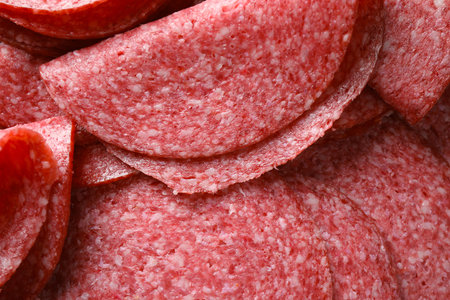 Slices of delicious sausage as background, closeupの写真素材
