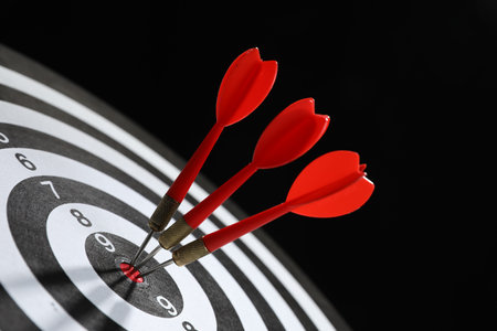 Targeting. Dart board with arrows on black background, closeupの写真素材