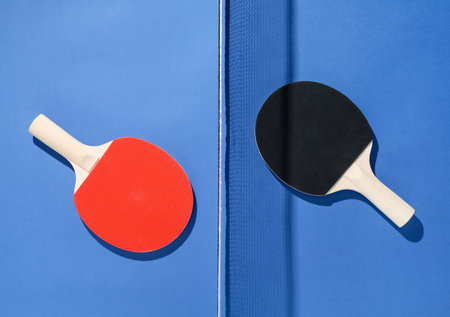 Ping pong rackets and net on blue background, flat layの写真素材