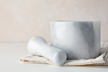 Marble mortar, pestle and cloth on white table, closeupの写真素材