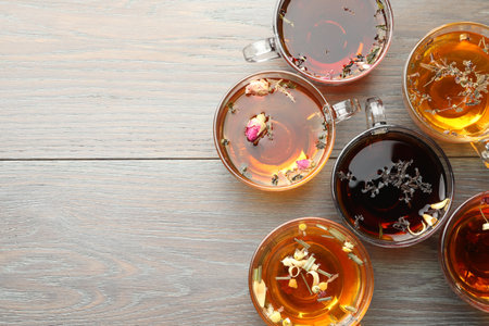 Aromatic herbal tea in glass cups on wooden table, flat lay. Space for textの写真素材