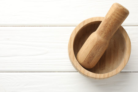 Mortar and pestle on white wooden table, top view. Space for textの写真素材