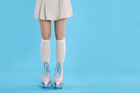 Woman in roller skates on light blue background, closeup. Space for textの写真素材