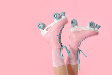 Woman in roller skates on pink background, closeup. Space for textの写真素材