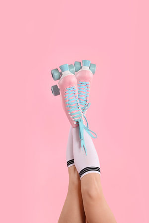 Woman in roller skates on pink background, closeup