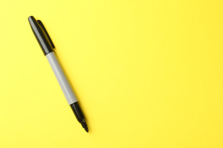 One black marker on yellow background, top view. Space for textの写真素材