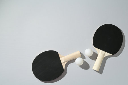 Ping pong rackets and balls on light background, flat lay. Space for textの写真素材