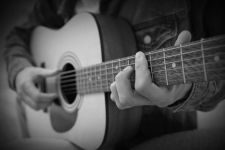 Man playing guitar, closeup. Black and white effect